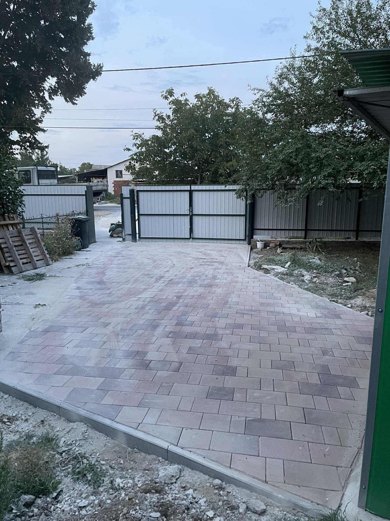 Rendezett térkövezés kapubejáróhoz, szegélykövezéssel és egységes burkolati kialakítással.
